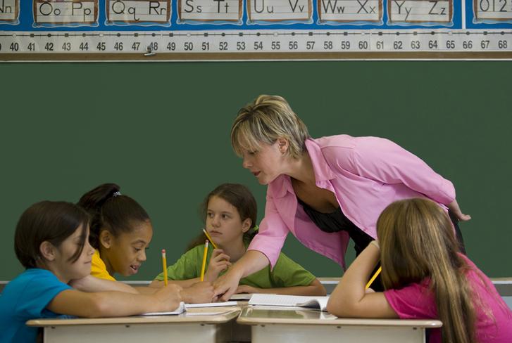 A teacher helps her students in the classroom