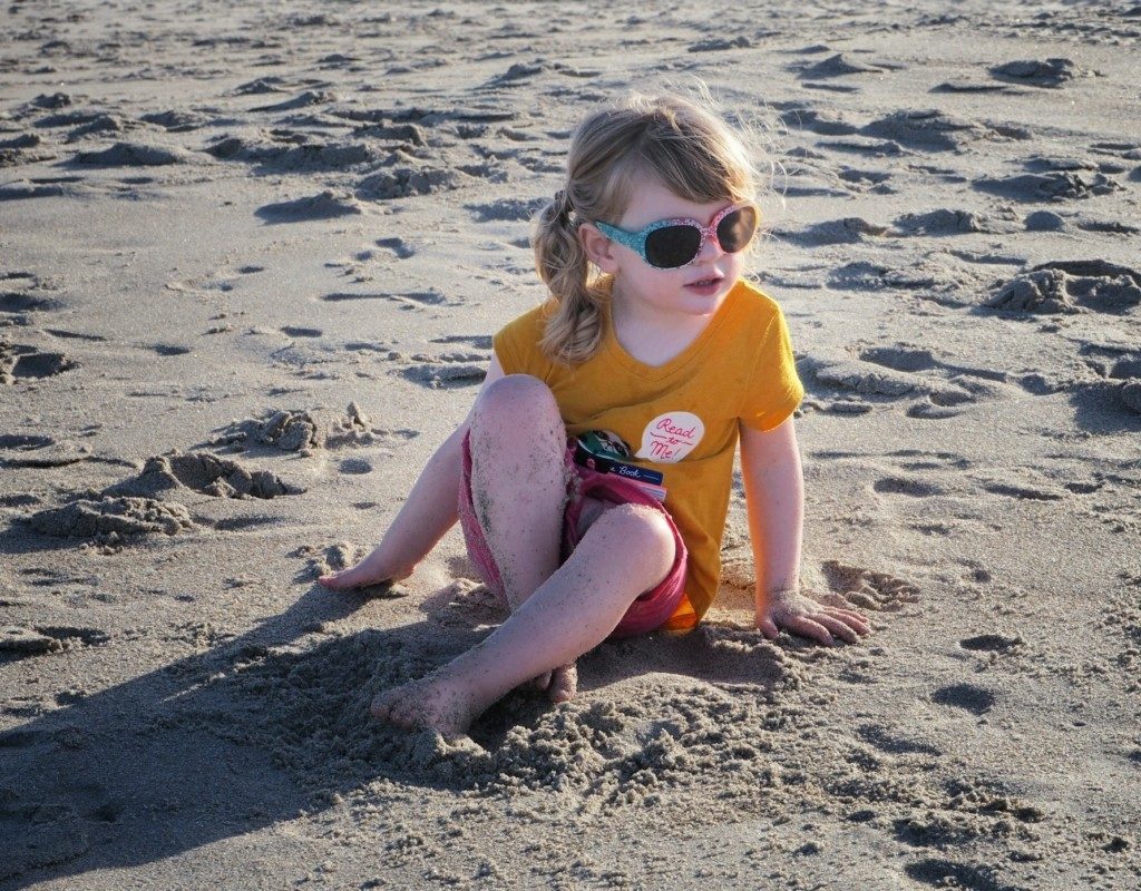 Toddler on beach in sunglasses