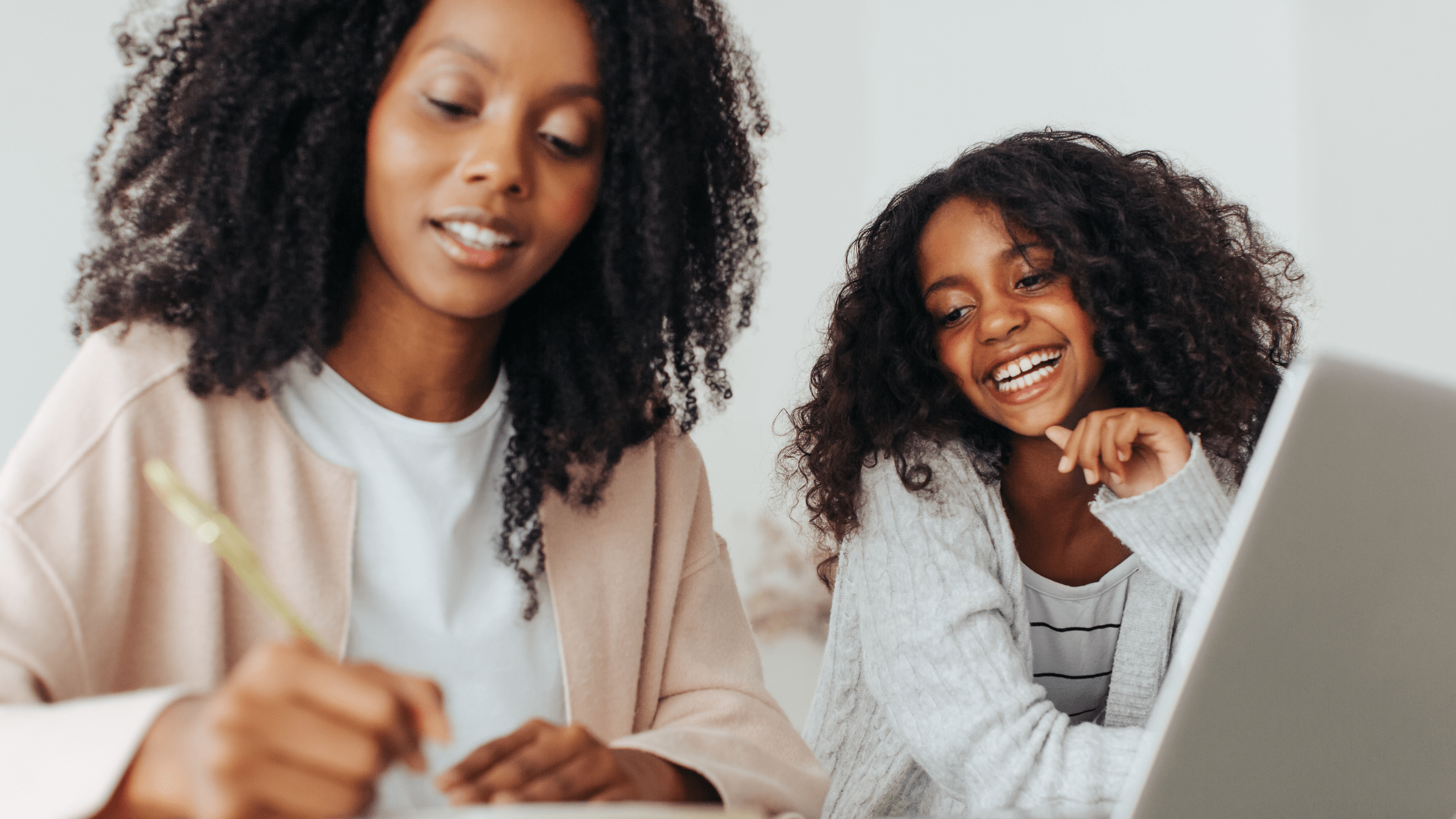 Mother and daughter writing New Year Momtras in front of computer