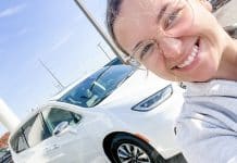 Woman in front of white hybrid minivan