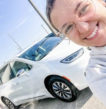 Indy Public EV Chargers Reviewed Woman in front of white hybrid minivan