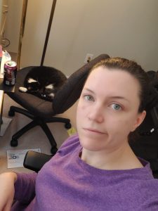 woman making face as cat sleeps